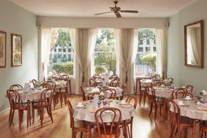 a dining room with tables and chairs and windows at Euro Hotel in London