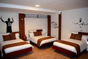 Una habitación de hotel con dos camas y un mural en la pared. en La Kapital Hotel, en Ambato 52 fotos más