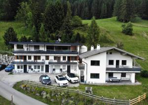 una casa grande con coches aparcados en un aparcamiento en Villa Haunold, en Sesto
