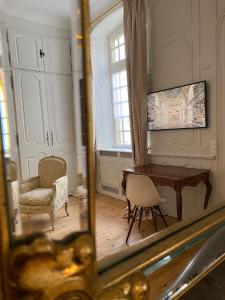 a mirror reflecting a room with a desk and a chair at L'APPARTEMENT by Merveilles de Marie in Lons-le-Saunier
