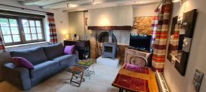 uma sala de estar com um sofá e uma lareira em La duvallerie chambre d hôte em Cangey