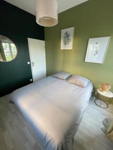 una camera con un grande letto su una parete verde di superbe villa au pied de Disneyland et val d'Europe a Serris