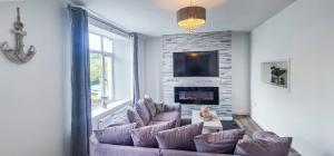 a living room with a couch and a fireplace at Driftwood Cottage, Luxury character cottage in The English Riviera, close to the picturesque precinct of St Marychurch, a short walk to the stunning beaches of Babbacombe and Oddicombe! in Torquay