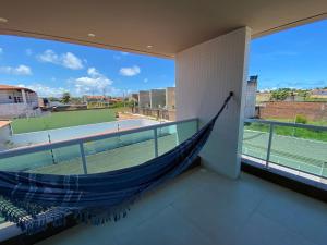 a hammock on the balcony of a tennis court at Casa de Praia Barra de São Miguel, 500mts Praia ( ER Hospedagens ) in Barra de São Miguel