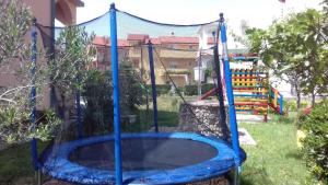 a blue trampoline in a yard with a playground at Lopar Apartment 3 in Lopar