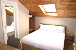 sypialnia z białym łóżkiem i świetlikiem w obiekcie Alis Hotel w Szkodrze
