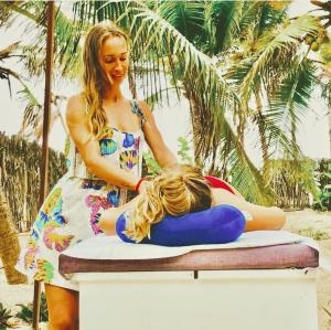 a woman in a dress sitting on a surfboard at Convento Arcádia in Atins