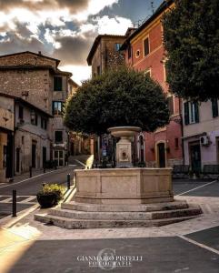 uma fonte no meio de uma rua com edifícios em La Petie Maison di Apricus em Olevano Romano