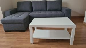 sala de estar con sofá y mesa de centro blanca en Mirando Llanes A B C, en Llanes