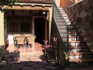 een patio met een tafel, stoelen en een trap bij A la Sombra de la Torre in Serra
