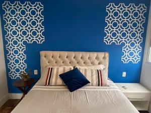 um quarto com uma cama com uma parede azul em Prédio frente mar 3 quartos Balneário camboriú BrisaMarBC3 em Balneário Camboriú
