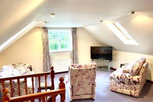 a living room with two chairs and a flat screen tv at Adorable 2 bedroom countryside guesthouse in Broom