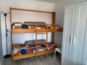 two bunk beds in a room with a lamp at Super duplex bord de mer, histoire nature sport. in Merville-Franceville-Plage