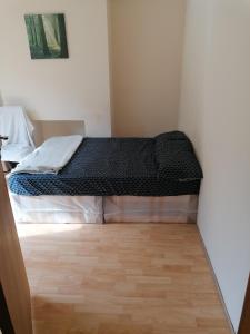 a bed in a small room with a wooden floor at Vob Property 76 in Hither Green