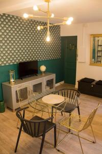 a living room with chairs and a table and a tv at Rempart Doré in Saint Malo