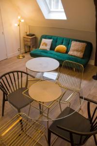a living room with two tables and a green couch at Rempart Doré in Saint Malo