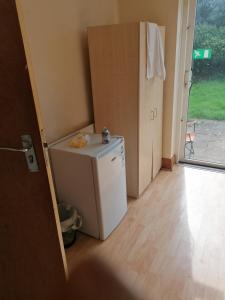 a kitchen with a small white refrigerator and a door at Vob Property 76 in Hither Green