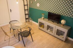 a living room with a table and a television on a entertainment center at Rempart Doré in Saint Malo