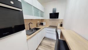a kitchen with white cabinets and a counter with a sink at Apartmán Tobias, PRIMO, Starý Smokovec in Starý Smokovec