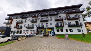 un gran edificio blanco con balcones. en Apartmán Tobias, PRIMO, Starý Smokovec, en Starý Smokovec