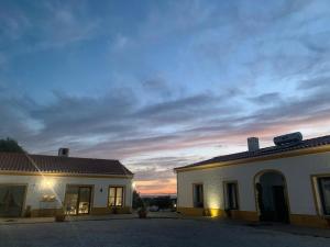 a building with a sunset in the background at Herdade Da Maridona - Agroturismo in Estremoz