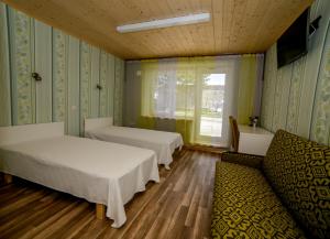 um quarto com duas camas e um sofá e uma janela em Puise Nina Guest House em Puise
