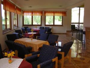 a dining room with tables and chairs and windows at Penzión pod Barancom in Žiar