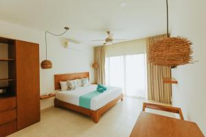 a bedroom with a bed and a dresser at Hotel Boutique Naj Casa Holbox in Holbox Island