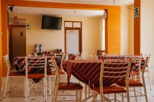 a room with a table and chairs and a television at Marlon's House Puno-Peru in Puno