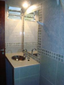 La salle de bains est pourvue d'un lavabo et d'une douche. dans l'établissement Residencial Santiago Habitaciones Hotel bed & break fast, à Posadas