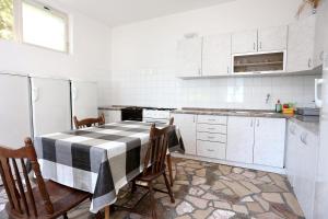 a kitchen with a black and white table and chairs at Triple Room Trpanj 258a in Trpanj