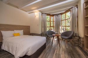 1 dormitorio con 1 cama, mesa y sillas en AVA Valle Sagrado Spot, en Urubamba