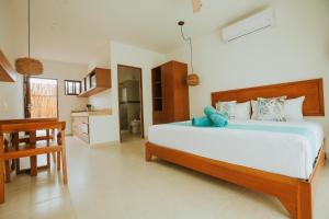 a bedroom with a large bed and a kitchen at Hotel Boutique Naj Casa Holbox in Holbox Island