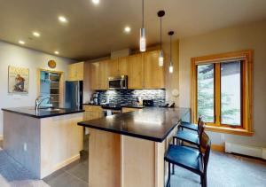 a kitchen with a large island in the middle at Lion Square Lodge Condos by TO in Vail