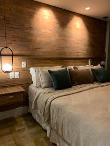 a bedroom with a large bed with a wooden wall at Granja Brasil in Itaipava