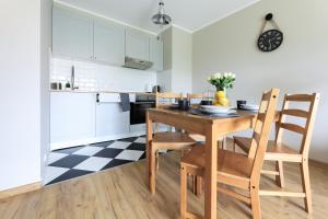 a kitchen with a dining room table and chairs at Sea Zone Climatic apartament by the bay in Puck