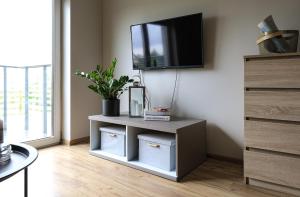 a living room with a tv on a wall at Sea Zone Climatic apartament by the bay in Puck