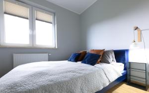 Un dormitorio con una cama con almohadas azules. en Sea Zone Climatic apartament by the bay, en Puck