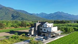 an aerial view of a house with mountains in the background at Furutasou B&B in Fenglin