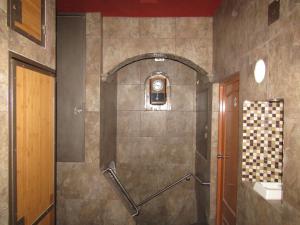 y baño con ducha y pared de azulejos. en Ruma San Luis Hotel Boutique, en San Luis Potosí