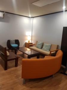 uma sala de estar com sofás e cadeiras num quarto em 1박전용 cosmo lounge 휴계실 em Saipan