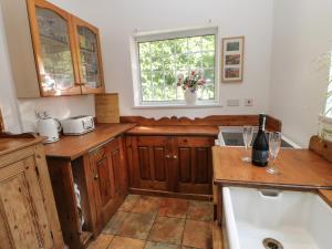 a kitchen with wooden cabinets and a window at Rosewood Cottage in Durham