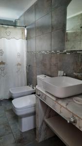 ein Badezimmer mit Waschbecken, Toilette und Badewanne in der Unterkunft ballena franca in Puerto Madryn