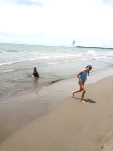 卡塔赫納的住宿－Exclusivo apartamento en Cartagena con vista al mar，和海里男人一起在海滩上散步的年轻女孩