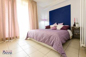 a bedroom with a purple bed with a blue wall at Lillananna Reload in Porto SantʼElpidio