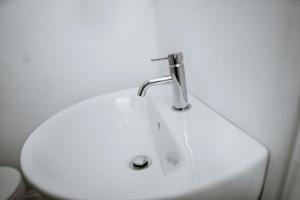 a bathroom sink with a faucet and a toilet at Zest Apartment One in Manchester