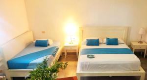 2 Betten in einem Zimmer mit blauer und weißer Bettwäsche in der Unterkunft RELAX STUDIES DELUXE SOL CARIBE in Punta Cana