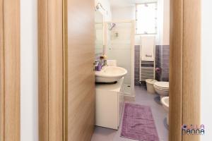 La salle de bains est pourvue d'un lavabo et de toilettes. dans l'établissement Lillananna Reload, à Porto SantʼElpidio