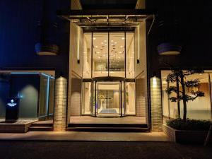 岡山的住宿－HOTEL MYSTAYS Okayama，一座建筑物,前门在晚上有照明