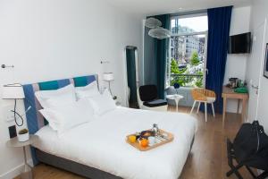 a bedroom with a bed with a tray of fruit on it at The Originals Boutique, Hôtel Le Lion, Clermont-Ferrand in Clermont-Ferrand